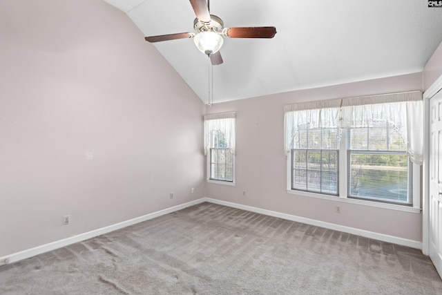 empty room with baseboards, lofted ceiling, ceiling fan, and carpet flooring