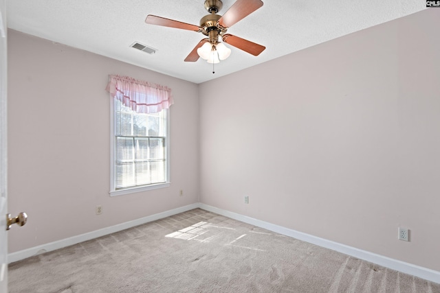 empty room featuring visible vents, baseboards, light colored carpet, and a ceiling fan