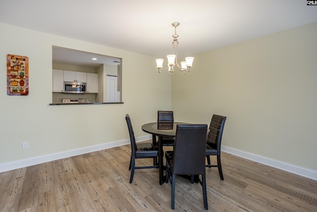 dining space featuring a notable chandelier, recessed lighting, light wood-type flooring, and baseboards