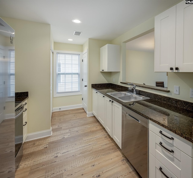 kitchen with a sink, visible vents, dishwasher, and white cabinetry