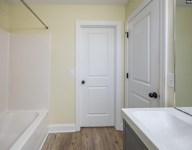 bathroom with vanity, wood finished floors, and baseboards