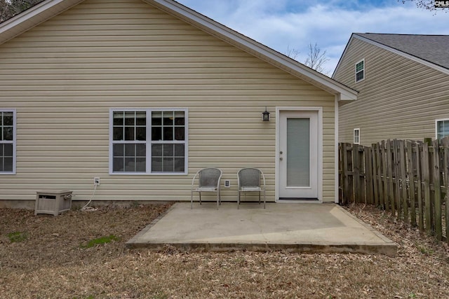 rear view of property featuring fence and a patio area