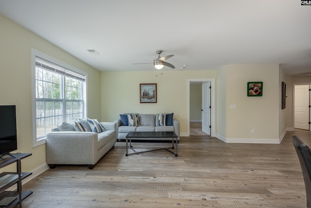 living room featuring baseboards, wood finished floors, visible vents, and ceiling fan