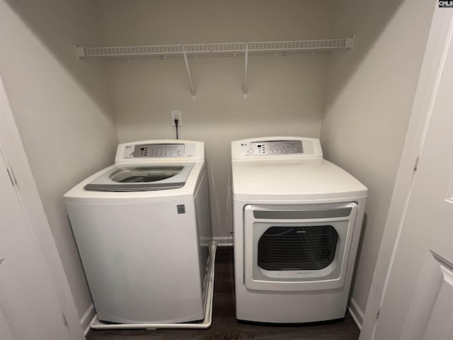 washroom featuring wood finished floors, washing machine and dryer, and laundry area