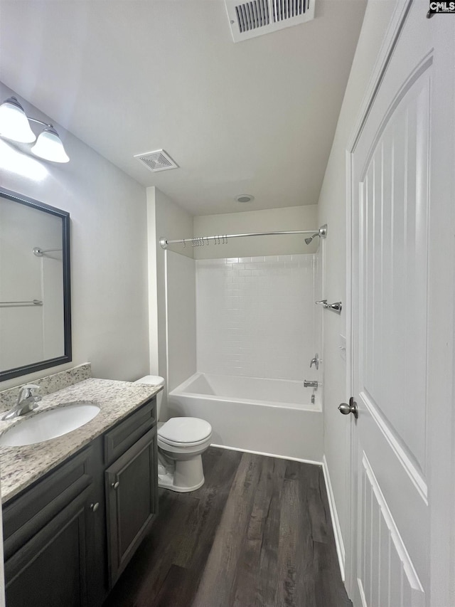 bathroom with visible vents, toilet, bathing tub / shower combination, wood finished floors, and vanity