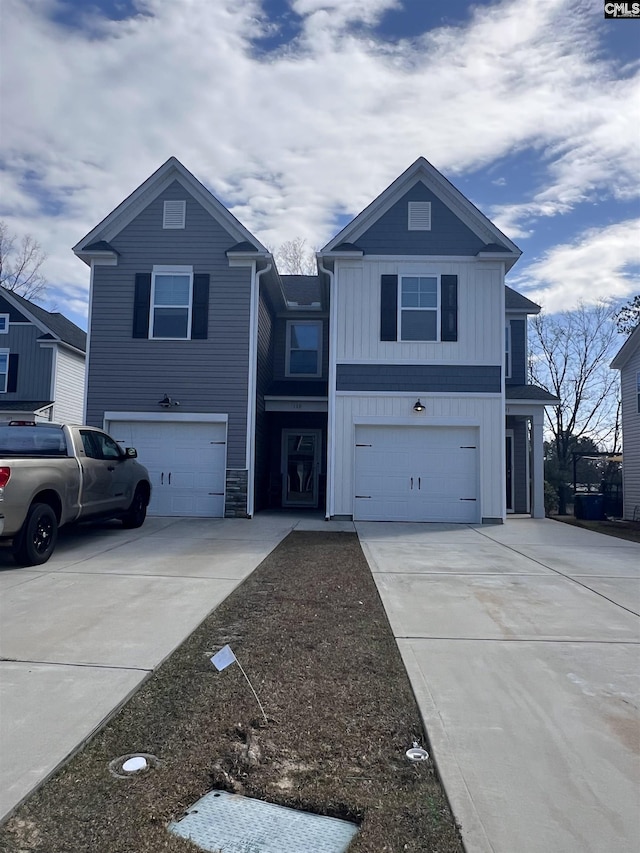 traditional-style home featuring an attached garage, concrete driveway, and board and batten siding