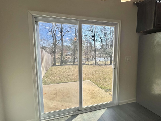 doorway to outside featuring wood finished floors and baseboards