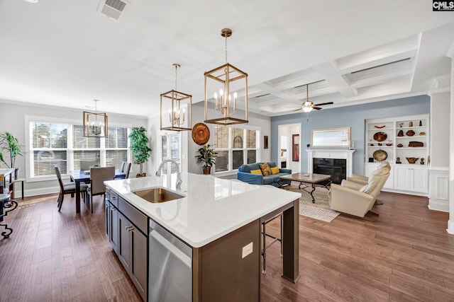 kitchen with a glass covered fireplace, visible vents, a sink, dark wood-type flooring, and stainless steel dishwasher