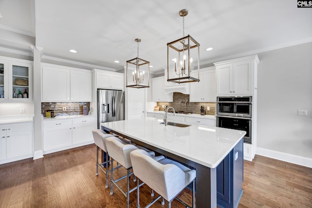 kitchen featuring dark wood-style flooring, appliances with stainless steel finishes, white cabinetry, and a sink