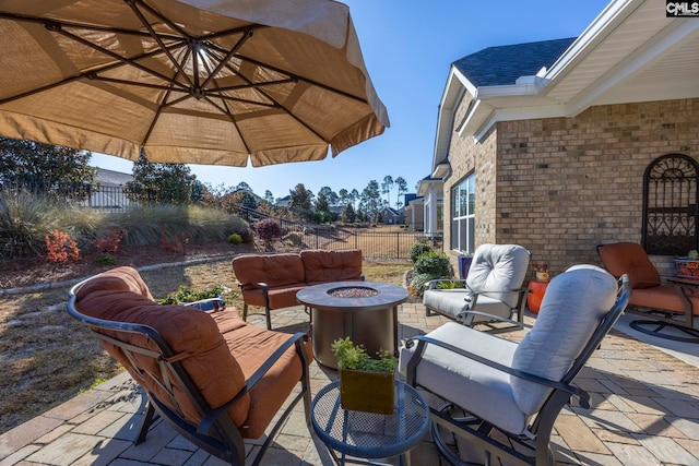 view of patio featuring an outdoor living space with a fire pit and fence