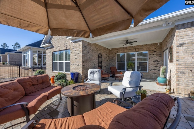 view of patio / terrace featuring an outdoor living space with a fire pit, a ceiling fan, and fence