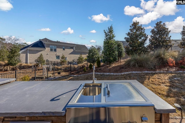 view of patio / terrace with a sink and fence