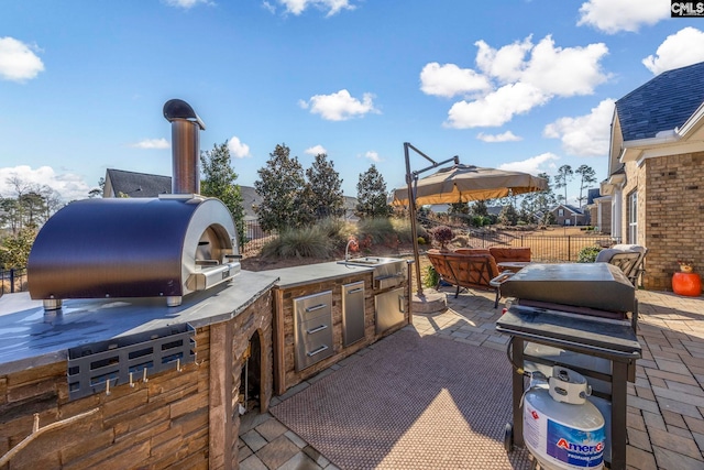 view of patio with an outdoor kitchen and fence