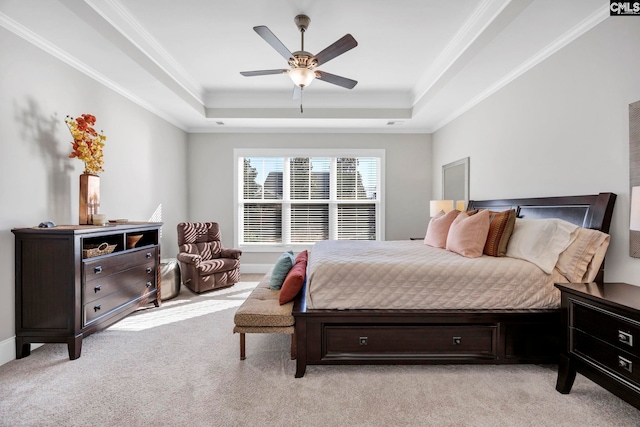 bedroom featuring a tray ceiling, light colored carpet, and ornamental molding