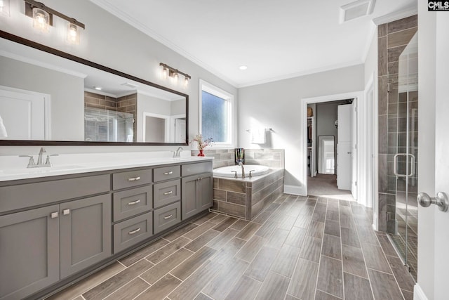 bathroom with visible vents, a sink, a shower stall, crown molding, and a bath