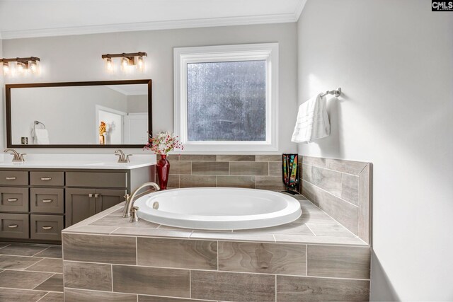 bathroom featuring double vanity, crown molding, a garden tub, and a sink