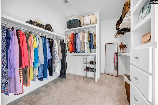 spacious closet featuring visible vents, carpet floors, and vaulted ceiling