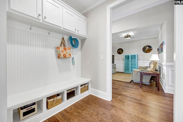 mudroom featuring a wainscoted wall, light wood-type flooring, and ornamental molding