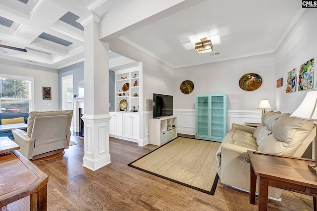 living room featuring beam ceiling, ornamental molding, coffered ceiling, wood finished floors, and ornate columns