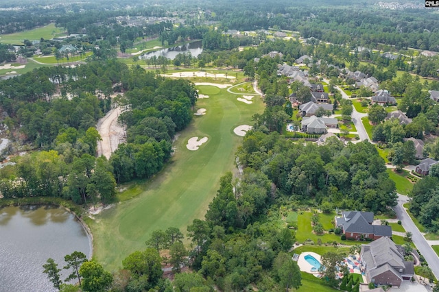 birds eye view of property with golf course view and a water view