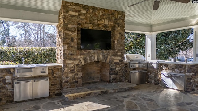 view of patio with grilling area, an outdoor kitchen, and an outdoor stone fireplace