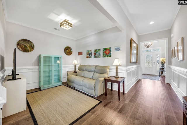 living room with visible vents, a wainscoted wall, wood finished floors, and crown molding