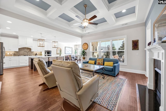 living room featuring visible vents, coffered ceiling, a fireplace with flush hearth, ceiling fan, and dark wood-type flooring