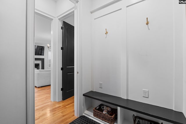 mudroom featuring a large fireplace and light wood-style floors