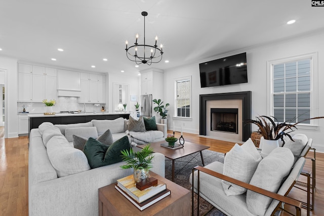 living area with a notable chandelier, recessed lighting, and light wood-style floors