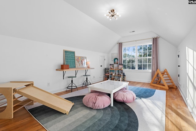 rec room featuring visible vents, baseboards, lofted ceiling, and wood finished floors