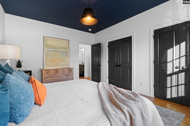 bedroom with a closet, baseboards, and wood finished floors