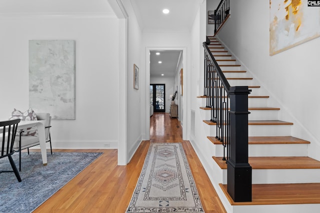 foyer featuring recessed lighting, ornamental molding, stairs, and wood finished floors