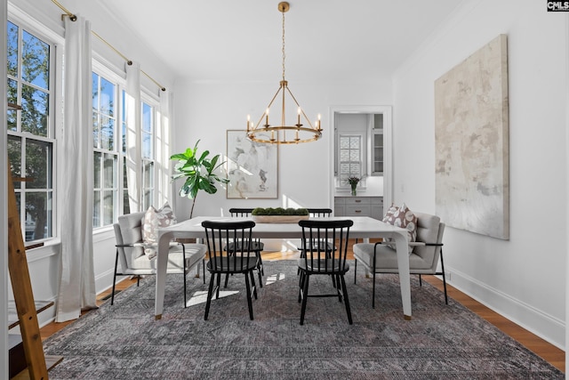 dining area with an inviting chandelier, wood finished floors, and baseboards