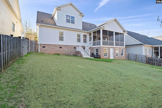 rear view of property with a lawn, board and batten siding, a fenced backyard, and a sunroom