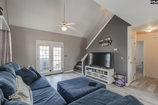 living area featuring stairway, french doors, light wood-type flooring, and ceiling fan