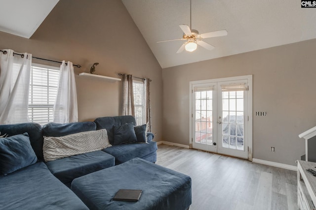 living room featuring french doors, a healthy amount of sunlight, ceiling fan, and light wood finished floors