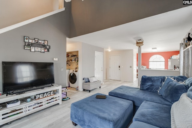 living room featuring separate washer and dryer and light wood finished floors