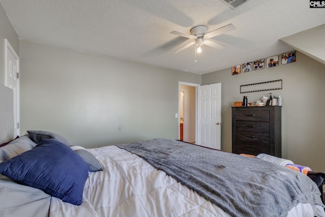 bedroom featuring a ceiling fan, visible vents, and a textured ceiling