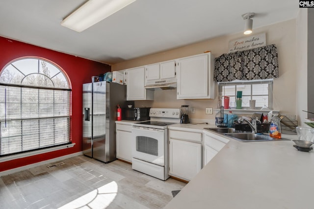 kitchen with under cabinet range hood, stainless steel refrigerator with ice dispenser, electric range, white cabinets, and a sink