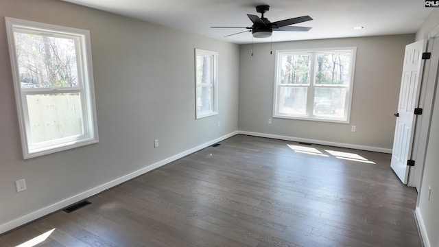 unfurnished bedroom featuring dark wood finished floors, baseboards, visible vents, and a ceiling fan