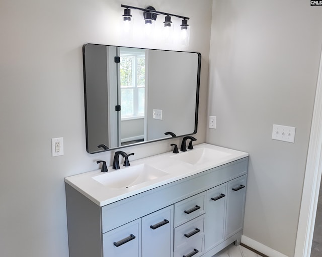 bathroom featuring a sink, baseboards, and double vanity