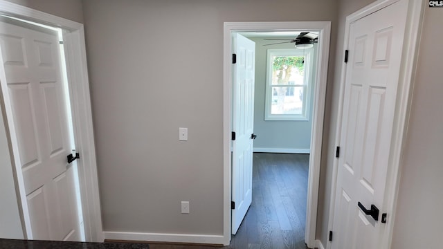 hall featuring dark wood-style floors and baseboards