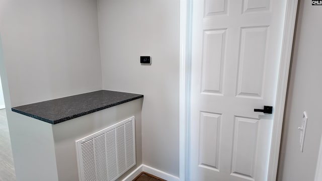 laundry room with electric dryer hookup, visible vents, and baseboards