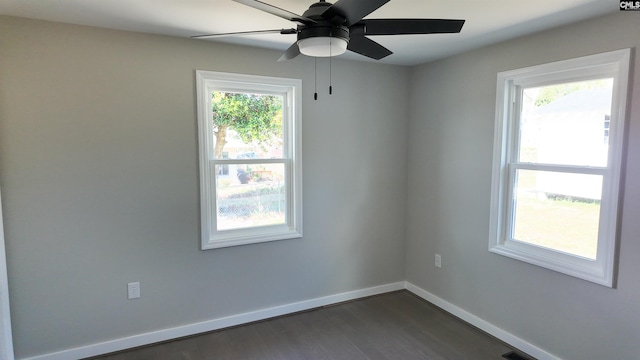 empty room with baseboards, dark wood-style floors, and a ceiling fan