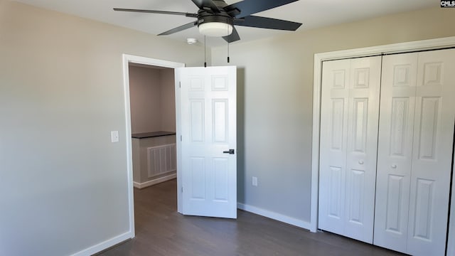 unfurnished bedroom with visible vents, ceiling fan, baseboards, a closet, and dark wood-style floors