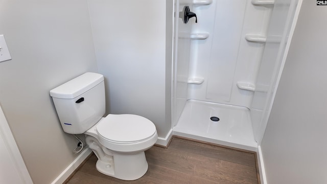 full bath with a shower stall, toilet, baseboards, and wood finished floors