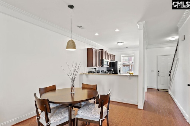 dining room with light wood finished floors, visible vents, crown molding, baseboards, and recessed lighting