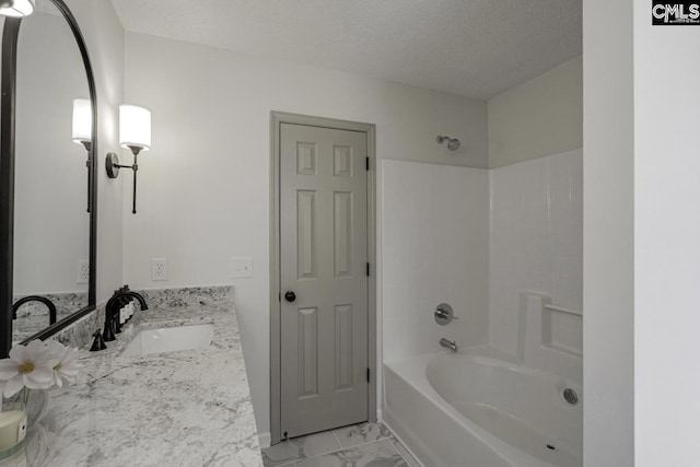 bathroom featuring vanity, bathing tub / shower combination, marble finish floor, and a textured ceiling