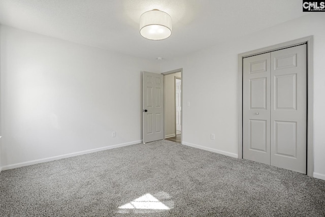 unfurnished bedroom featuring a closet, carpet flooring, and baseboards