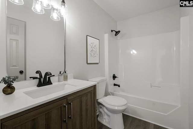 full bathroom with wood finished floors, toilet, shower / washtub combination, and vanity